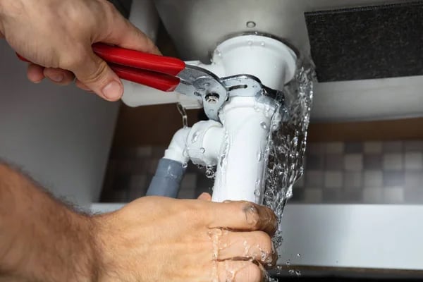 A plumber from Magenta Plumbing and Gas repairing under sink leak